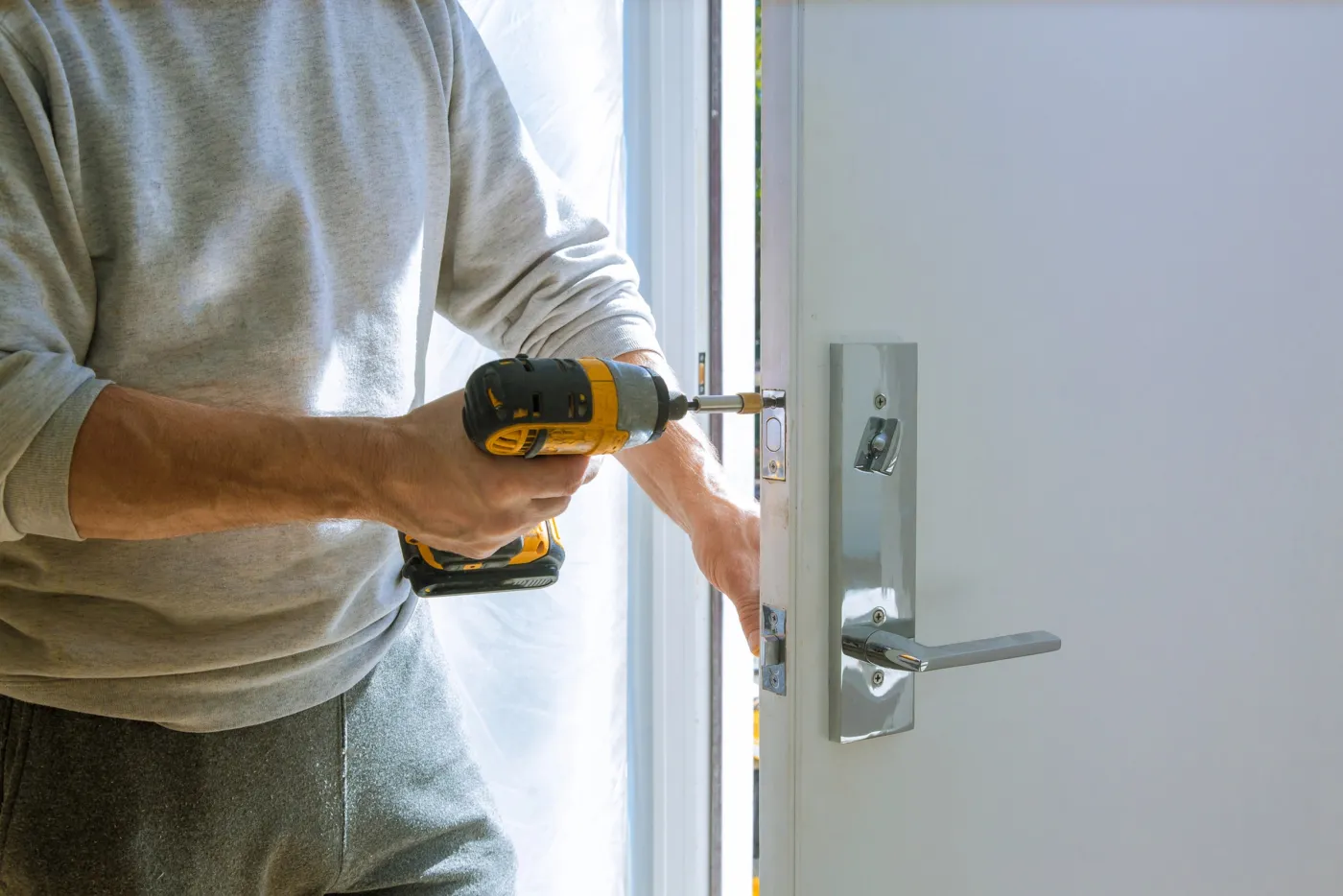Serrurier installant une serrure connectée sur une porte d'entrée en Île-de-France